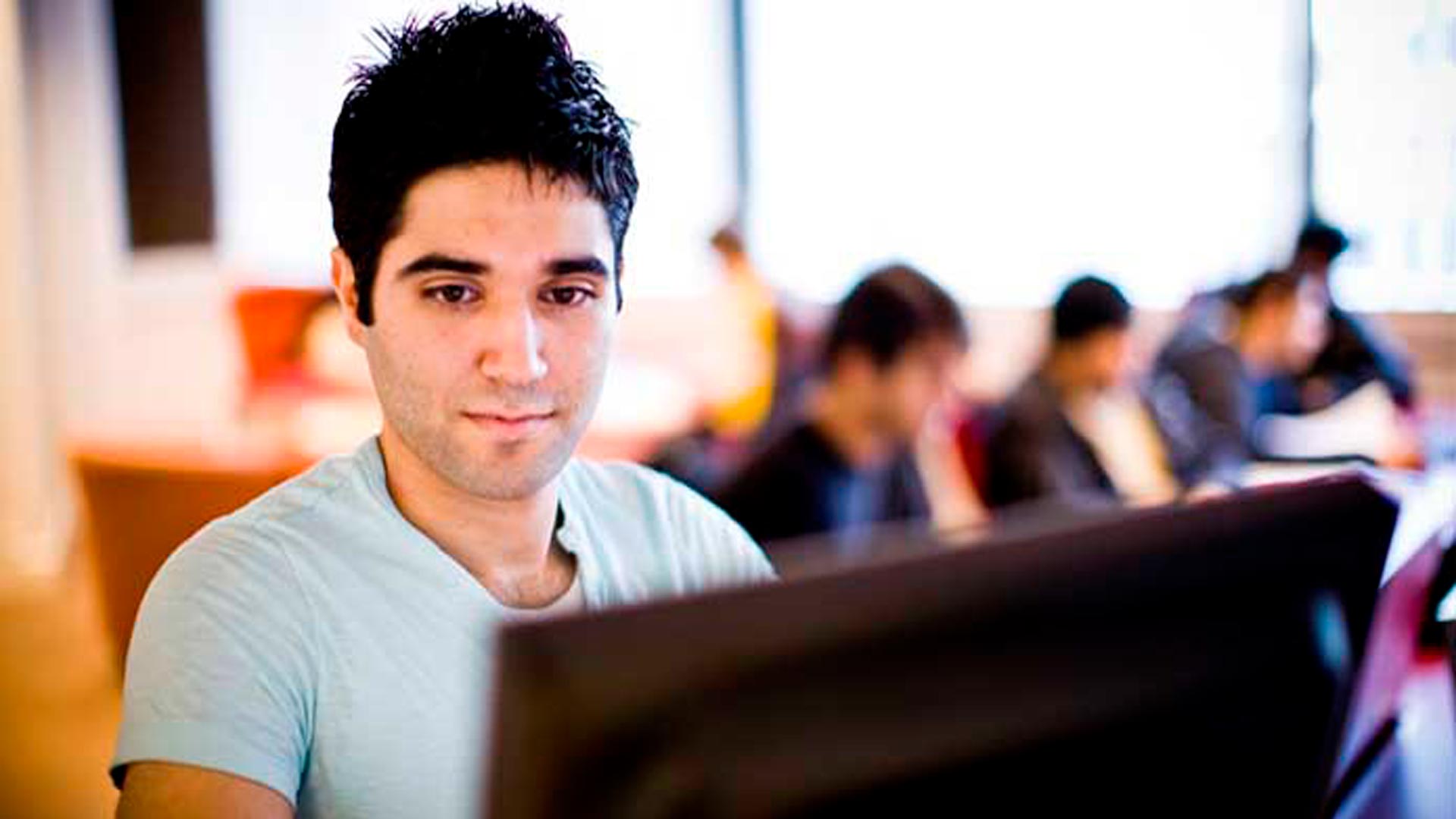 Student working on a laptop writing his blog.