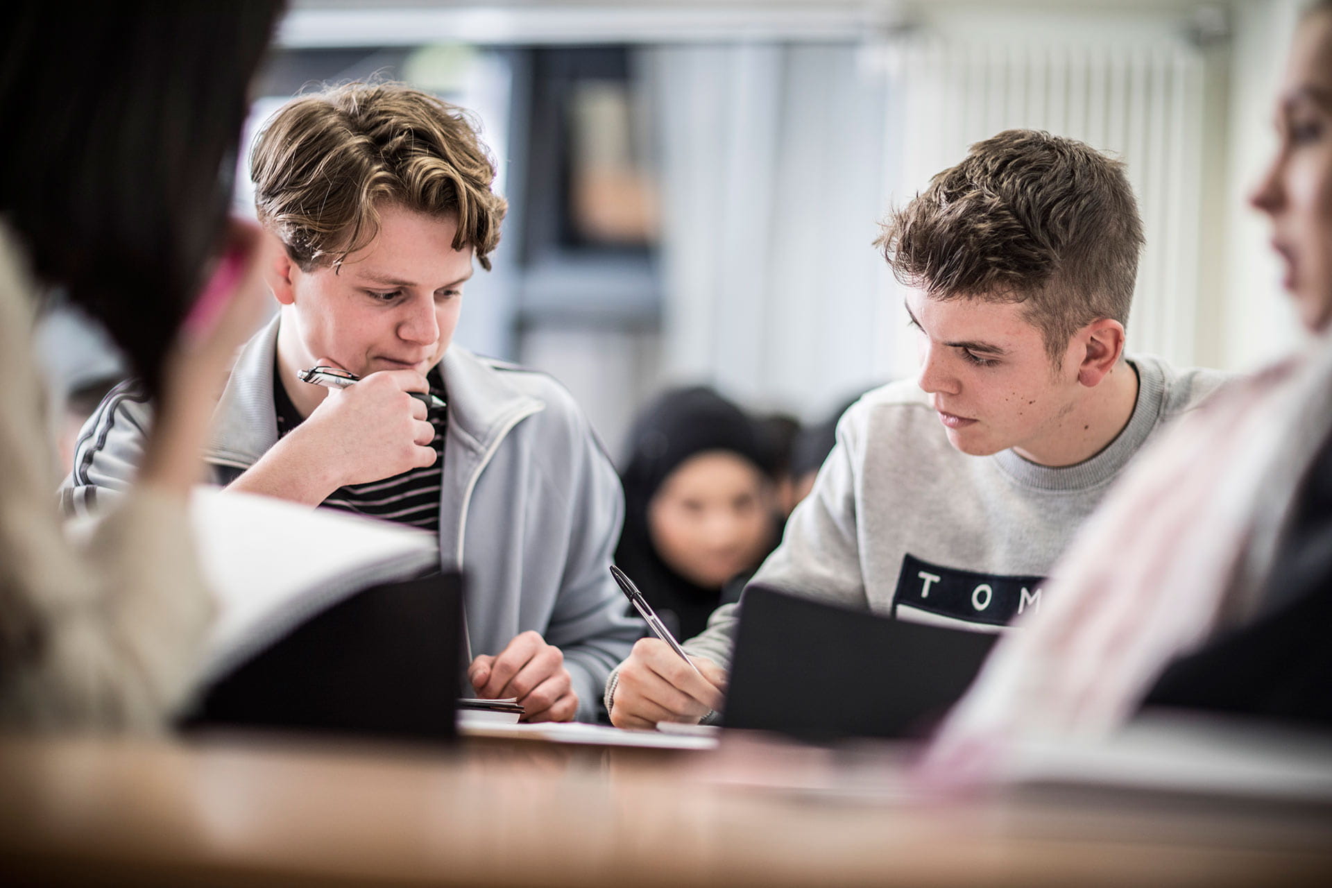 Students studying at a desk in a lecture