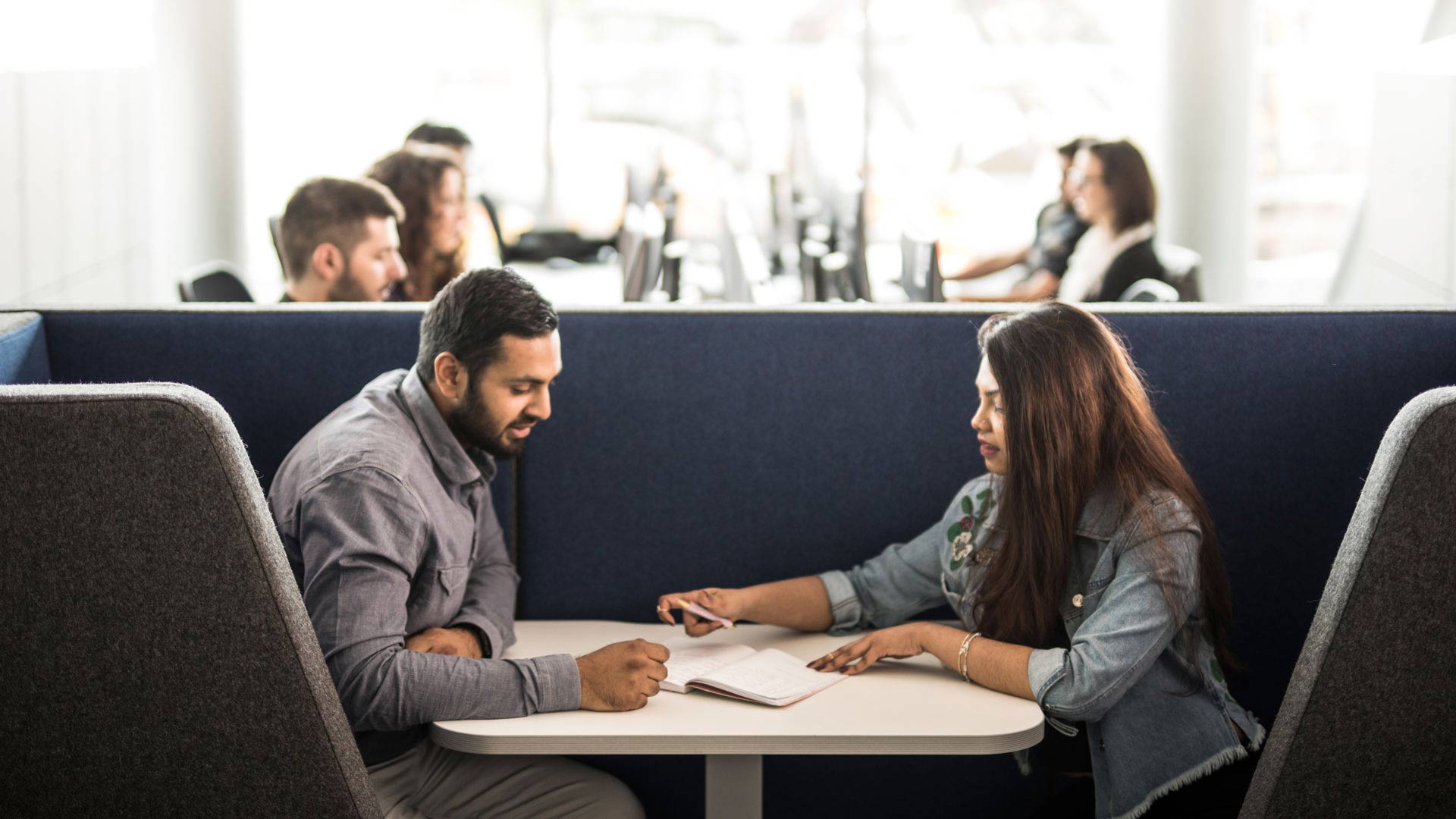 Students working together at a desk in a breakout area