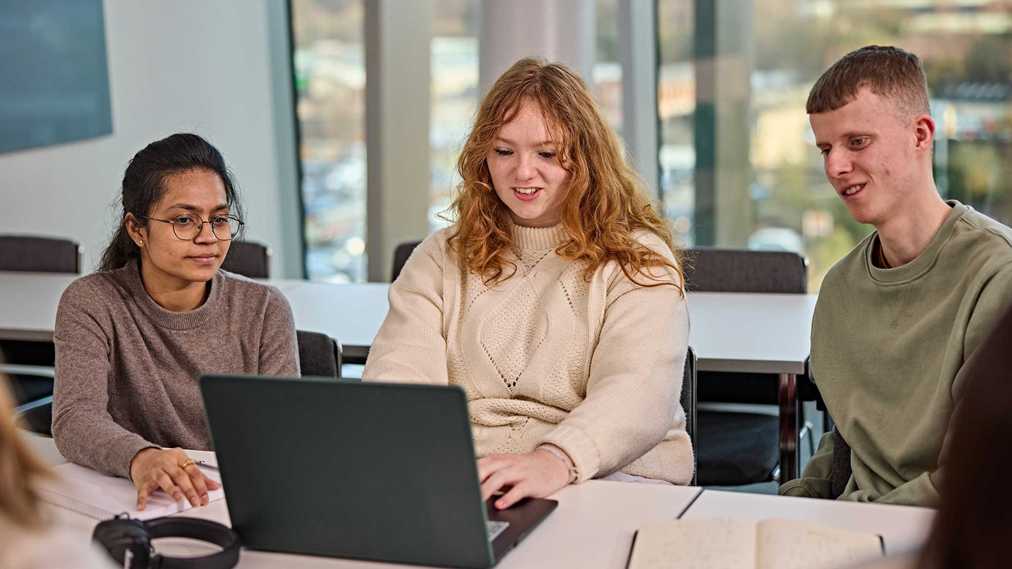 Three students studying on campus