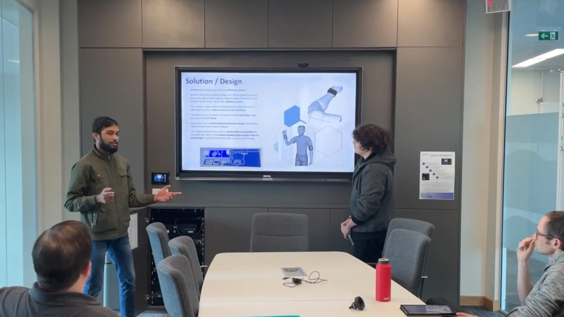 Ali and another student delivering a presentation to a small group.