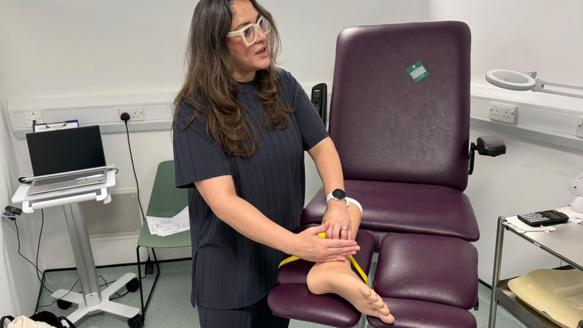 Syori Oates practising podiatry on a mannequin's foot.