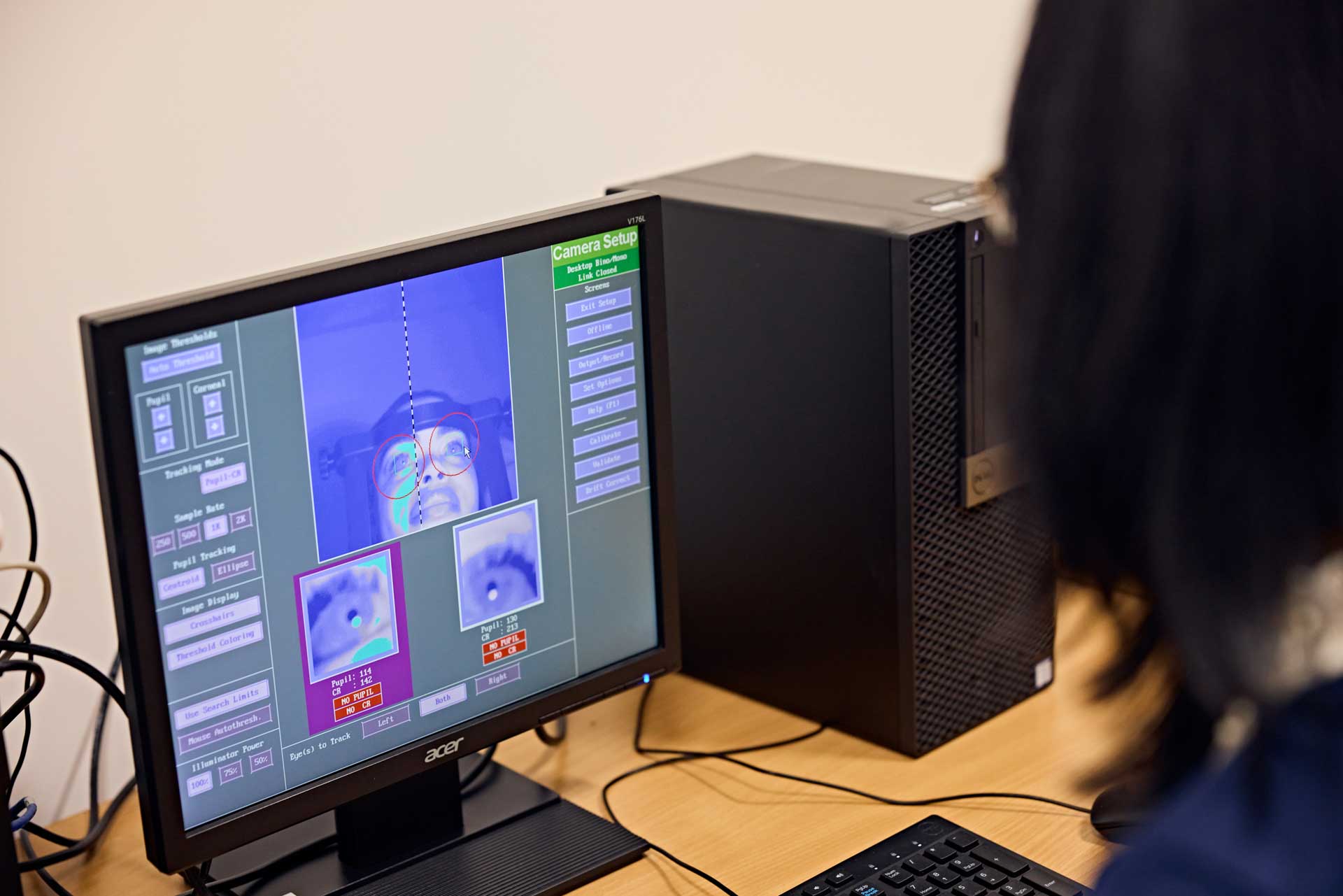 A psychology student calibrating the measurements of an eye tracking machine before using it to record the eye movements of a participant in their experiment.