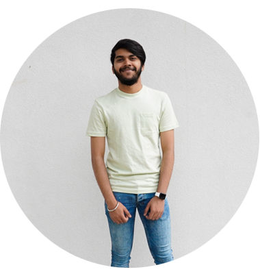 A man standing smiling in front of a cream background