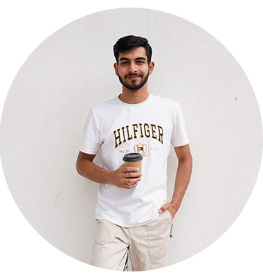 A man standing smiling in front of a cream background