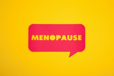 the word menopause in a red speech bubble on a yellow background