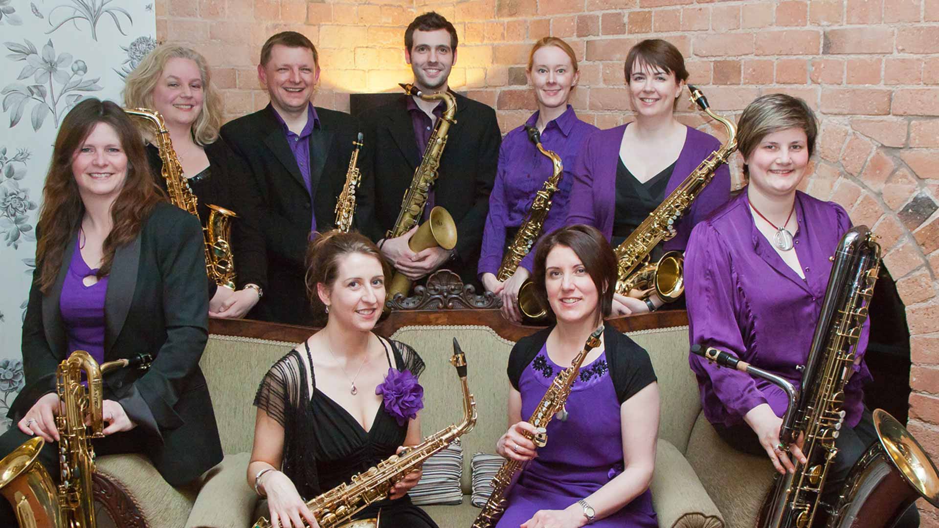 A group of saxophone players posing with instruments in hand.
